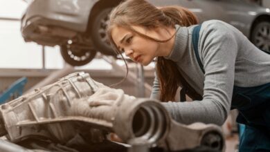 female mechanic fixing car engine